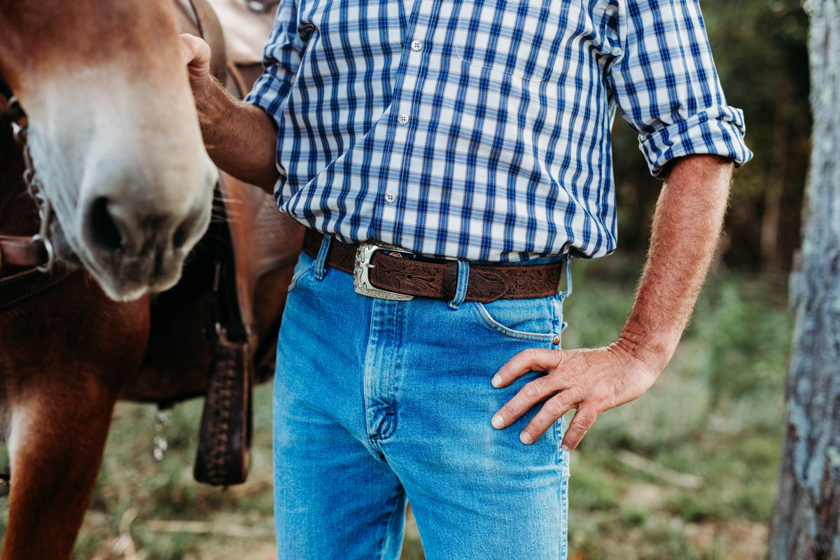 Man wearing the Reagan floral-embossed water buffalo belt with jeans