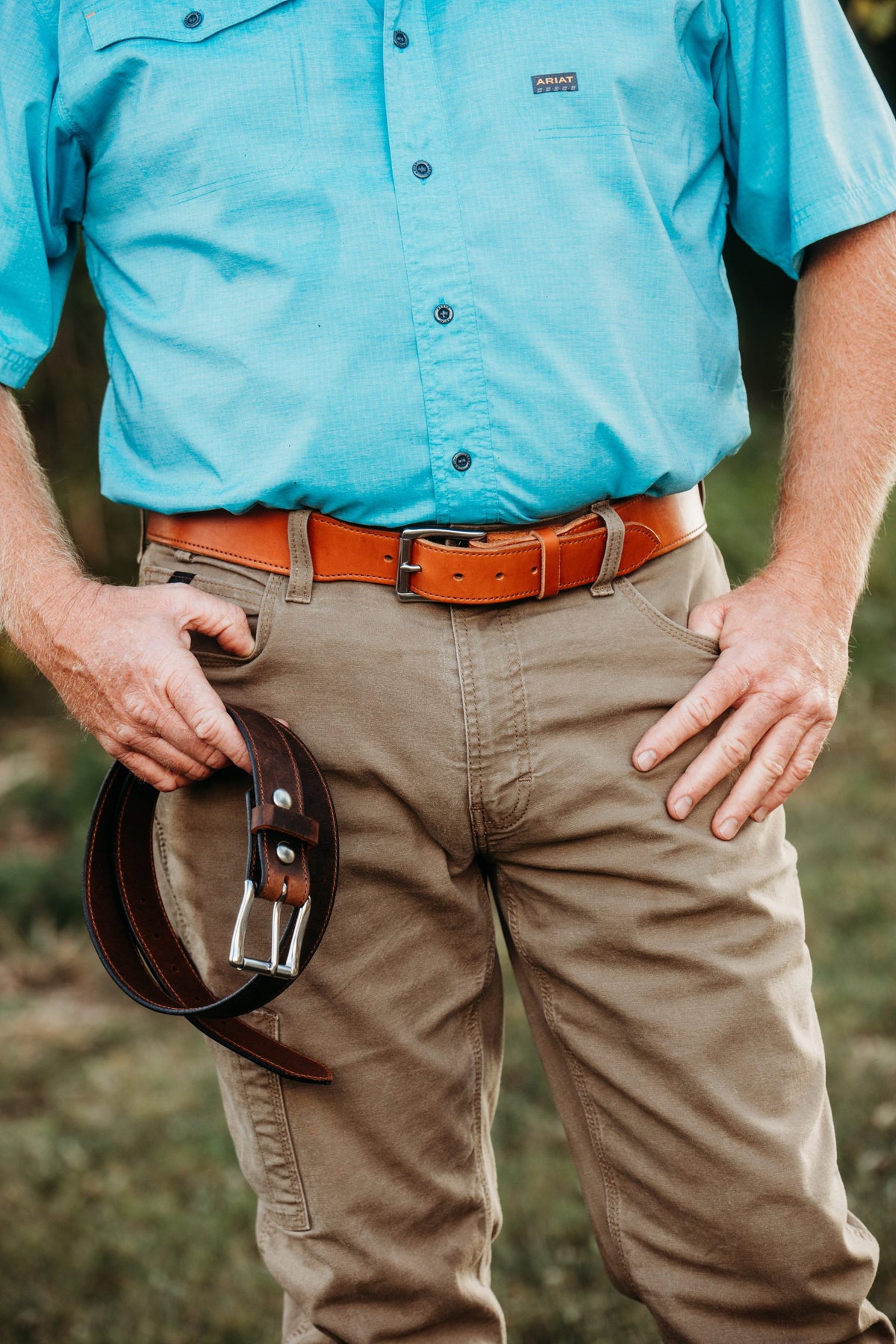 Man wearing and holding The Duke bridle leather belts