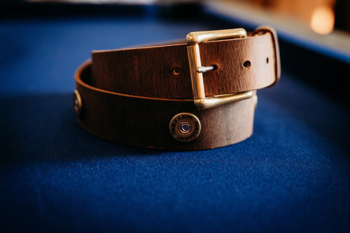 The Over Under water buffalo leather belt with brass ammo concho and roller buckle