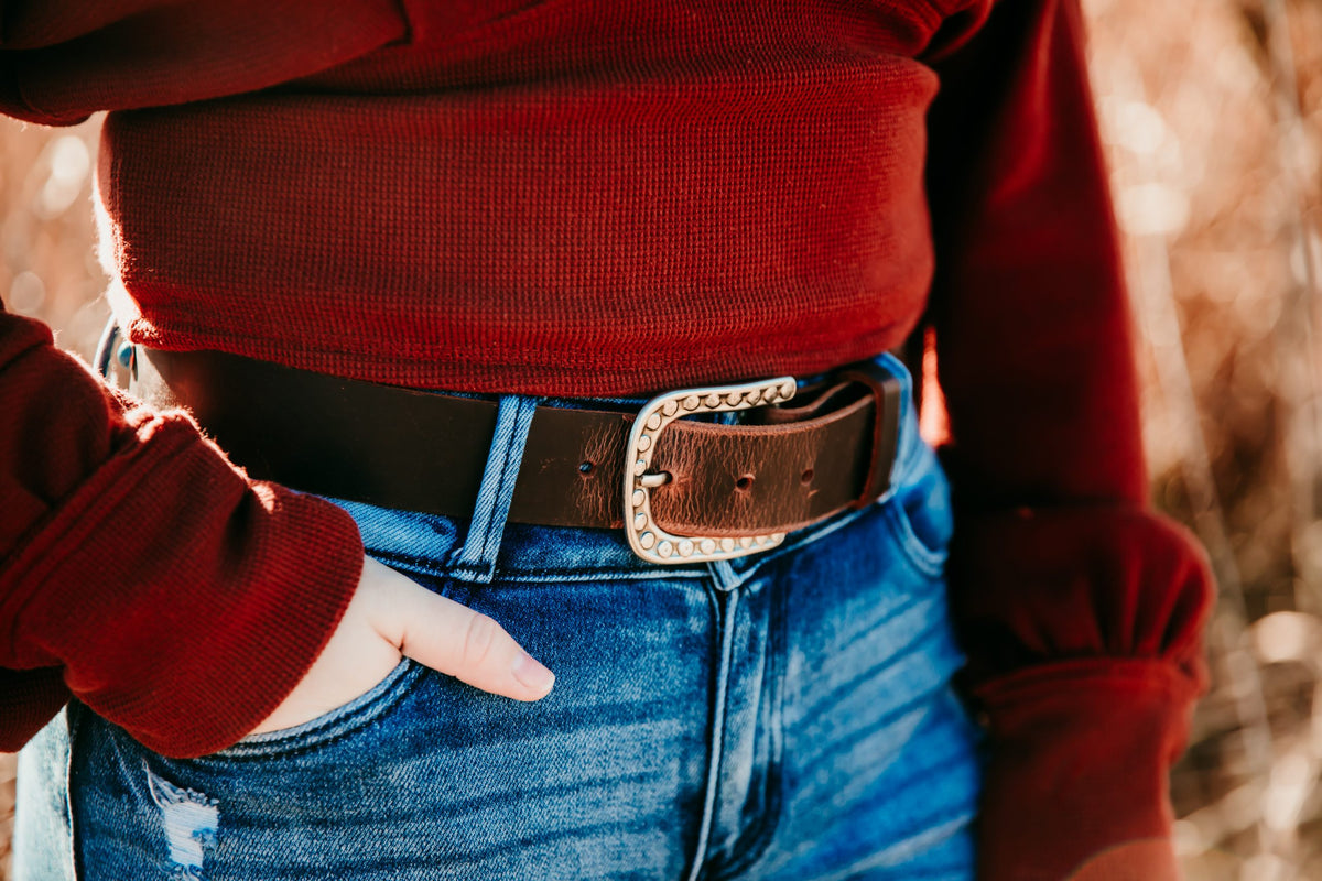 Woman wearing Ella distressed brown water buffalo belt with studded silver buckle