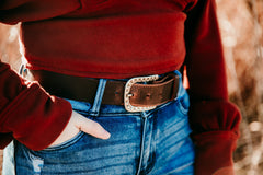 Woman wearing Ella distressed brown water buffalo belt with studded silver buckle