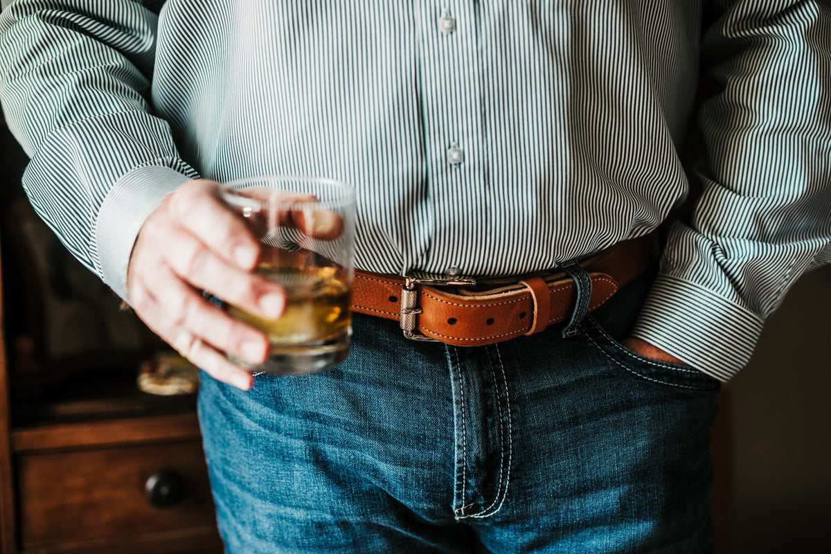 The Saturday harness leather belt worn with jeans, engraved roller buckle