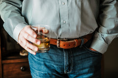 The Saturday harness leather belt worn with jeans, engraved roller buckle