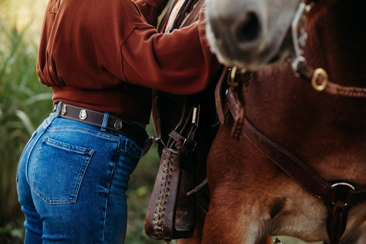 Claire water buffalo belt worn with jeans, horseshoe concho detail