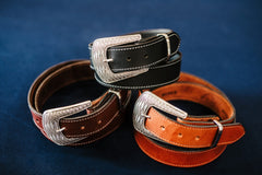 Clint water buffalo belts with ornate silver and black western buckles