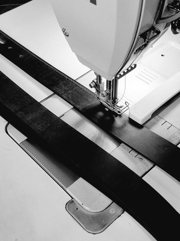 Sewing machine stitching a leather belt